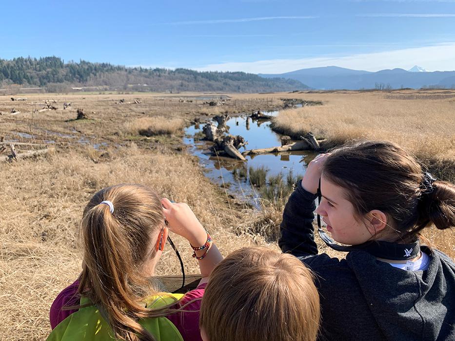 students look through binoculars at Gibbons Creek