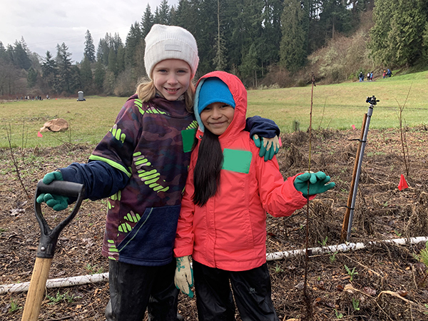 students pose while planting trees