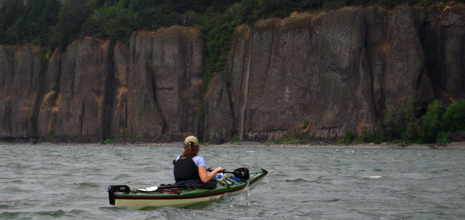 Kayaker on the water facing the cliffs of Cape Horn