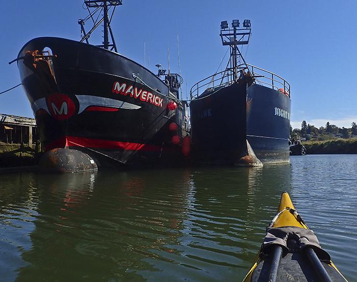 kayak faces two ships, one clearly marked with the name Maverick