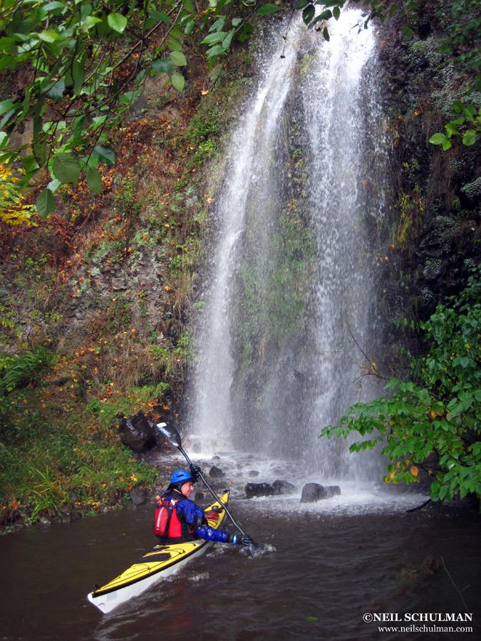 kayaker faces a small waterfall