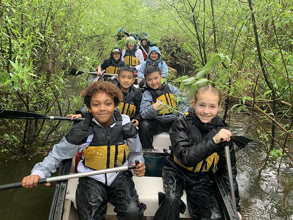 a canoe-full of students paddling on the Willamette River