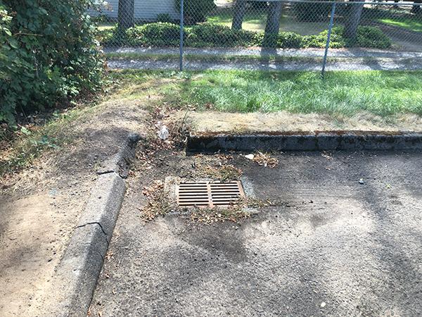 storm drain in the corner of a parking lot