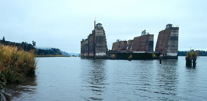 an abandoned barge sits offshore on the Columbia River