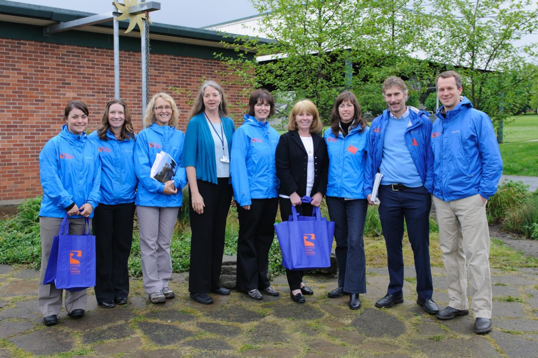 nine people in a row in matching blue rain jackets