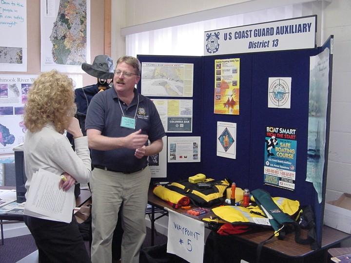 a person visits a US Coast Guard booth at an early water trail planning meeting