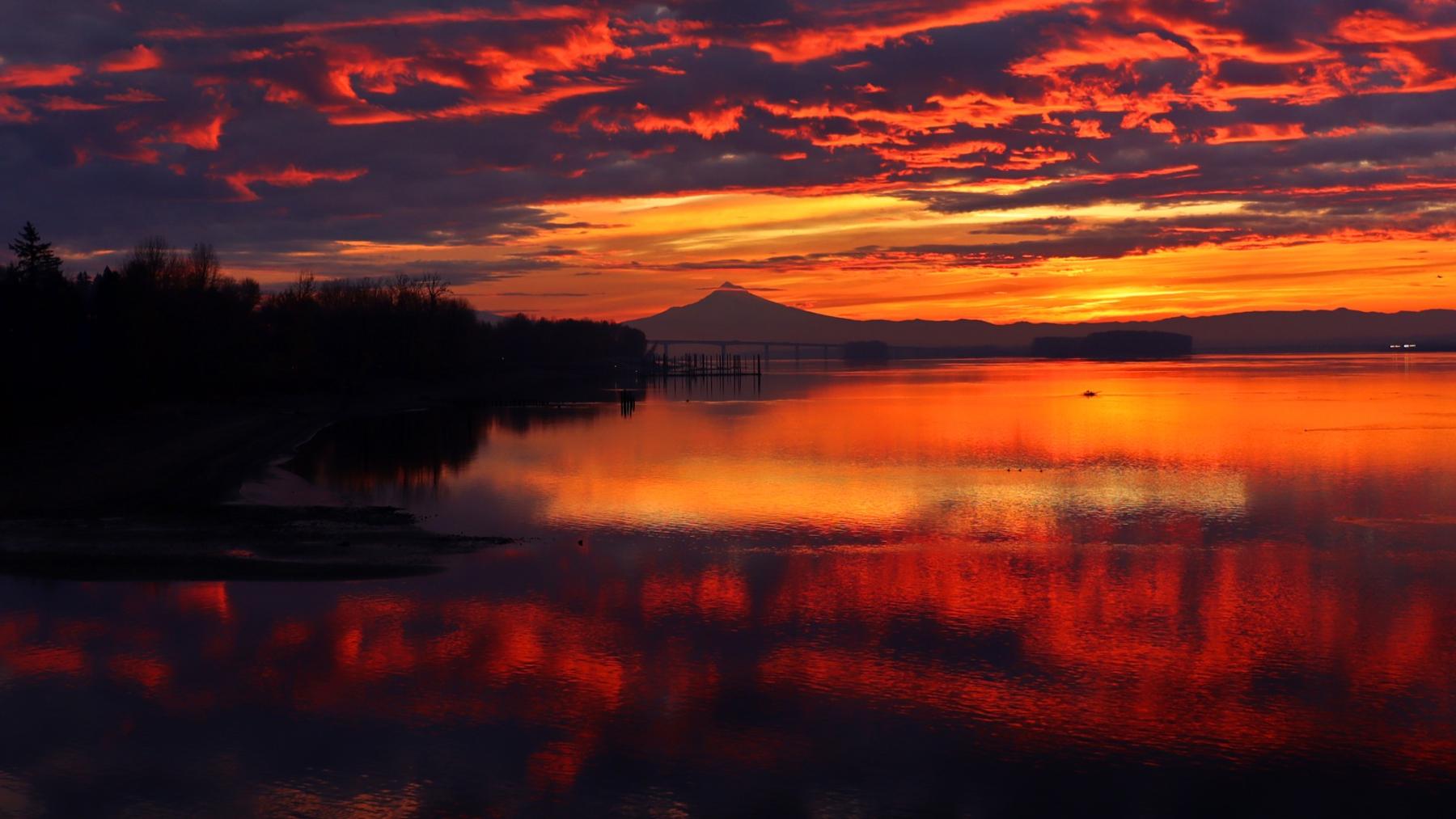 a colorful sunrise over the Columbia River with a silhouette of Mt. Hood in the distance