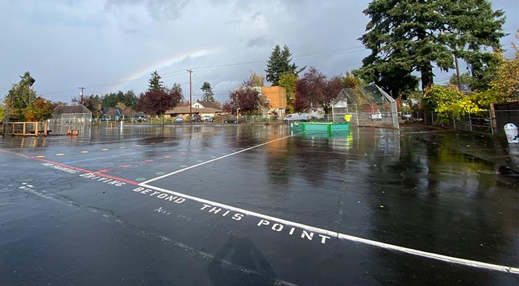rainbow over a large swath of asphalt in the schoolyard