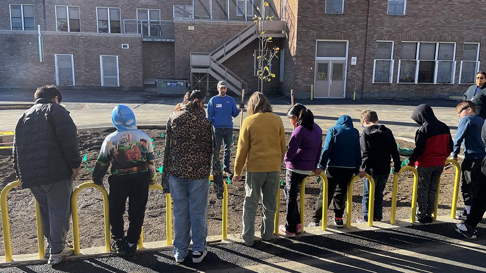 students face a stormwater swale where an educator is lecturing
