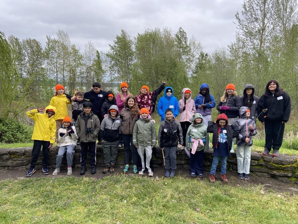 a group of students pose as a group on a short rock wall