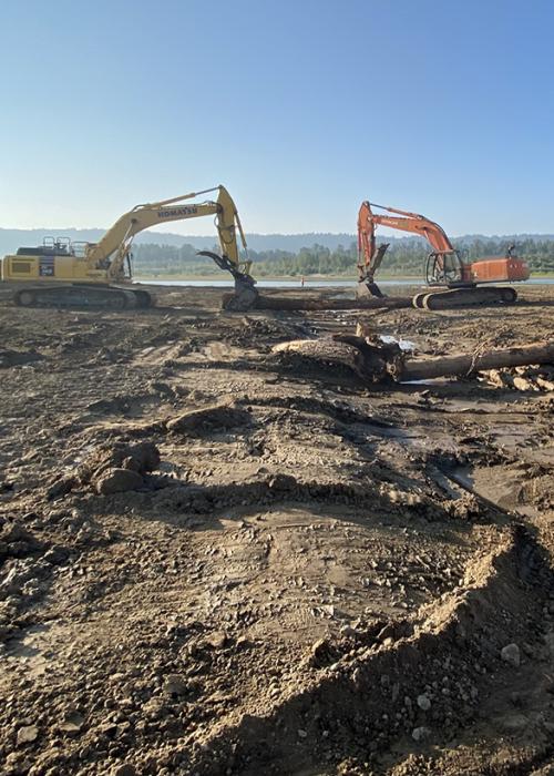 two excavators dig a new creek channel