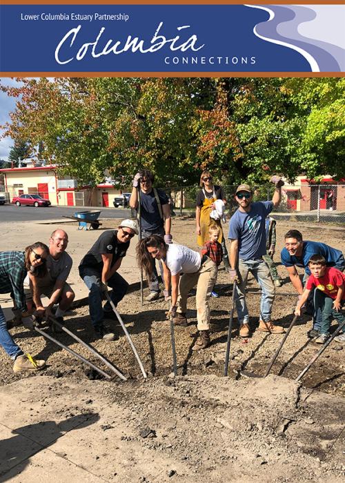 a group of people work together to pry up a chunk of asphalt