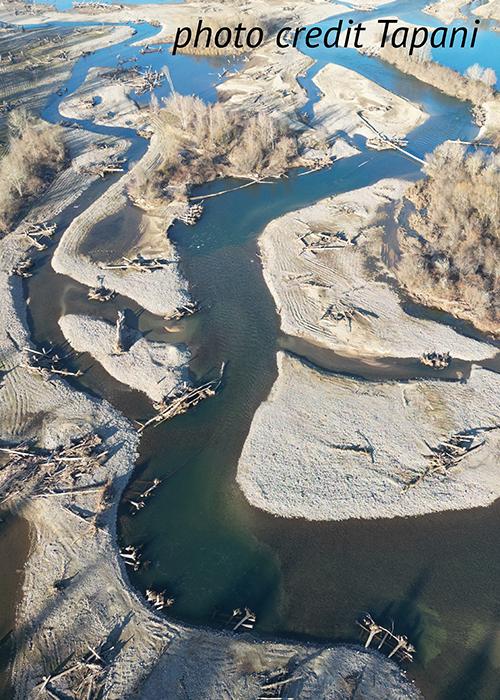 aerial view of a restored braided river with large wood anchored along the shore