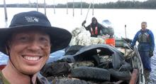 Andy and Chris pose with a boat full of trash
